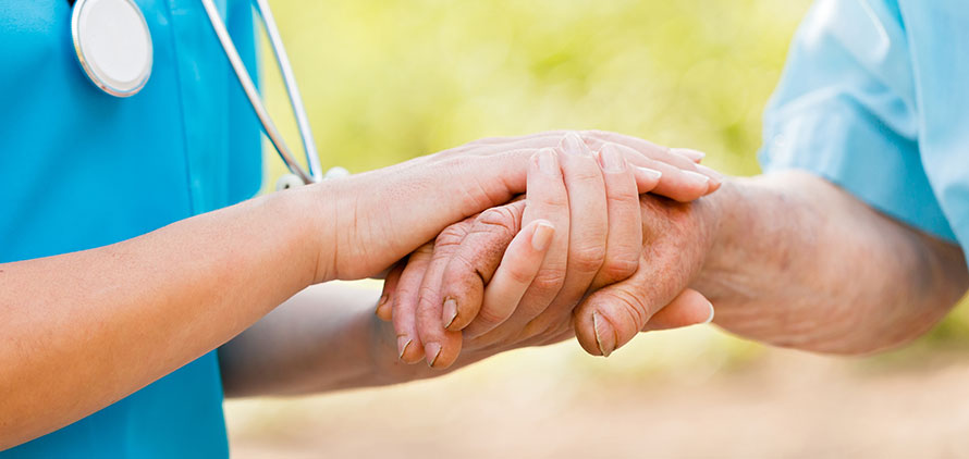 Photo of a nurse holding a hand